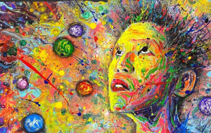 A person looks upwards with an explosion of colours and shapes all around them